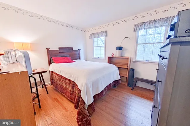 a bedroom with a bed next to a window with a dresser