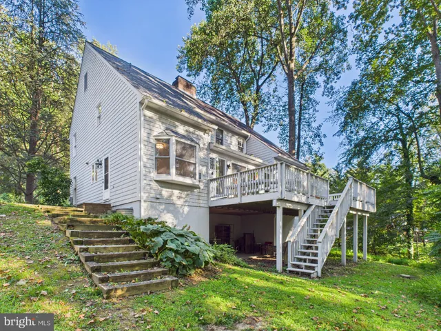 a view of a house with a yard and a large tree