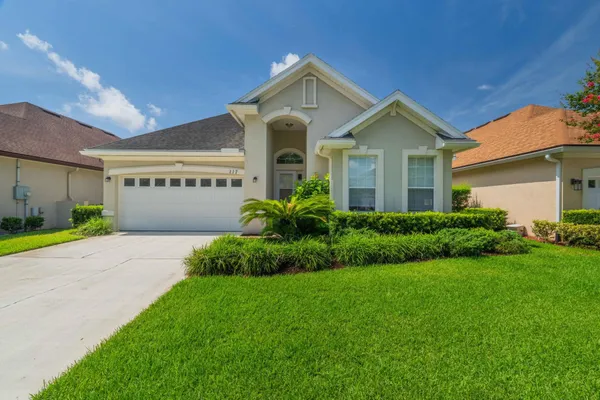 a front view of a house with a yard and garage