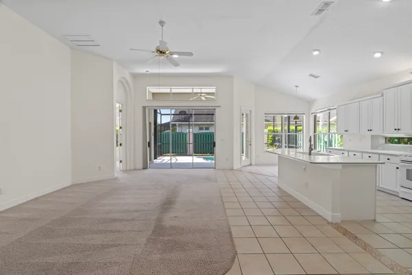 a large white kitchen with granite countertop a large window and white appliances
