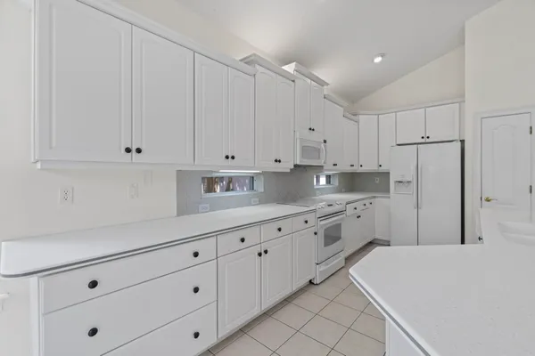 a kitchen with granite countertop white cabinets and stainless steel appliances