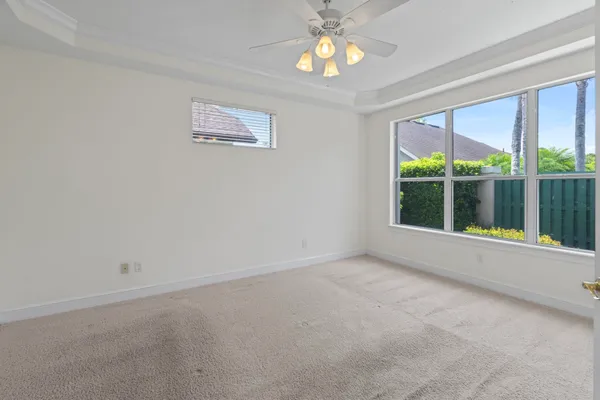 an empty room with a ceiling fan and a window