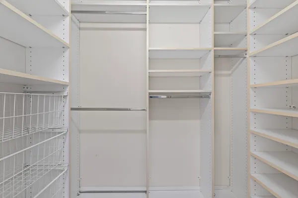 a spacious bathroom with a shower a sink and a mirror