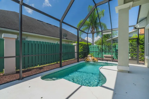 a view of a backyard with brick wall and potted plants