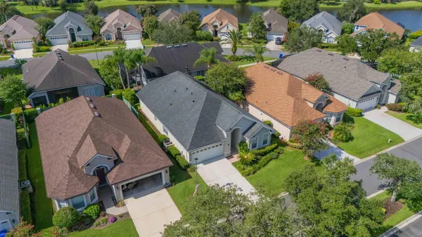 an aerial view of a house with a garden and lake view