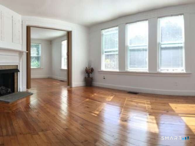 294 Church Street Guilford, CT 06437 - Photo 18 of 32 an empty room with wooden floor and a fireplace