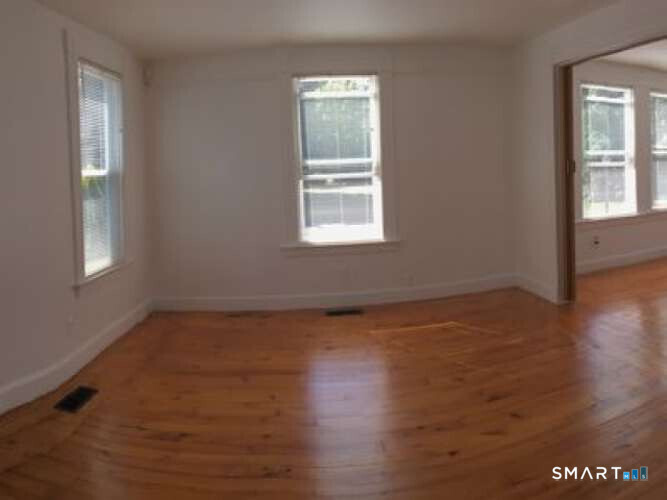 294 Church Street Guilford, CT 06437 - Photo 19 of 32 a view of an empty room with wooden floor and a window