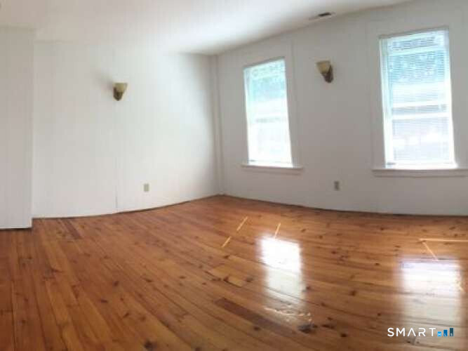 294 Church Street Guilford, CT 06437 - Photo 23 of 32 an empty room with wooden floor and windows