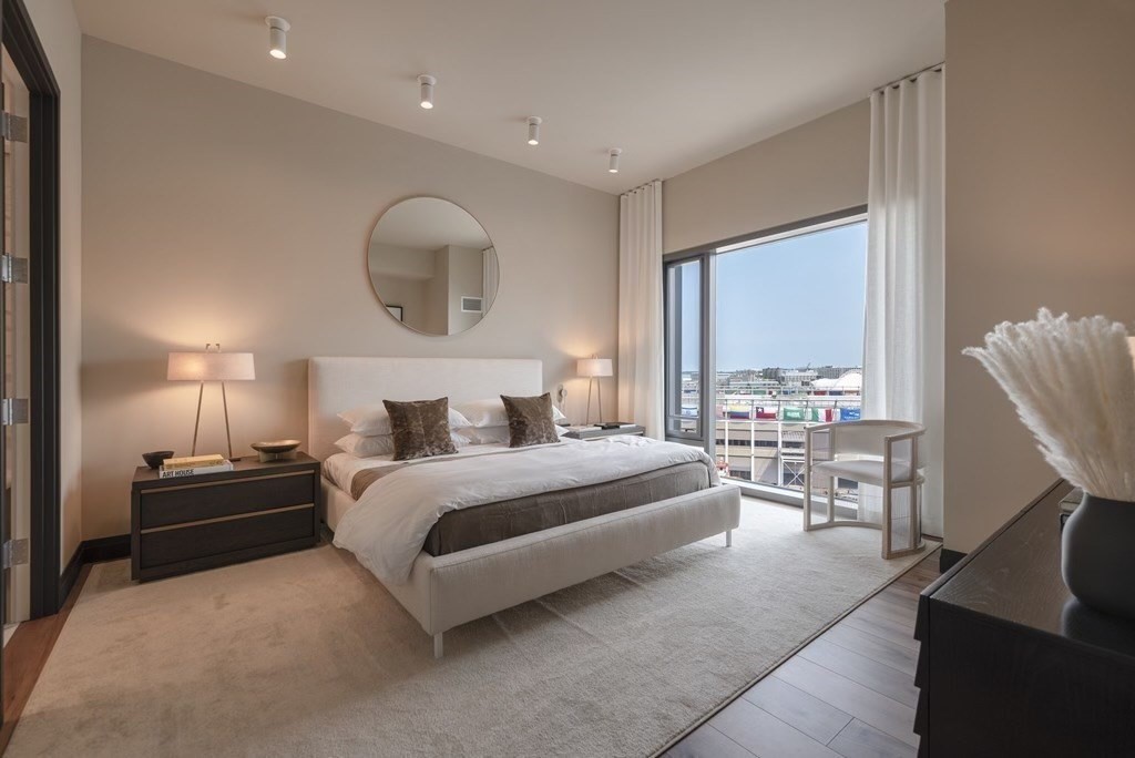 300 Pier 4 Blvd., Unit PHM Boston, MA 02210 - Photo 12 of 34 a spacious bedroom with a bed a mirror and a large window