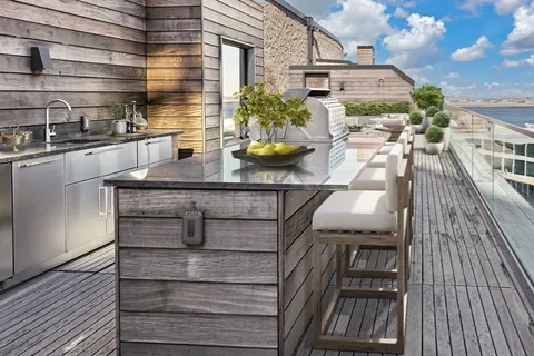 a view of a rooftop deck with couch and chairs