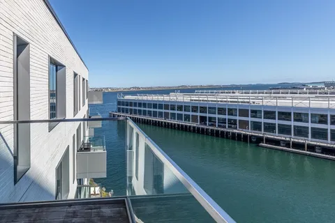a spacious bedroom with a bed a mirror and a large window
