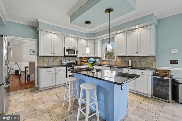 a kitchen with kitchen island granite countertop a sink stove and cabinets