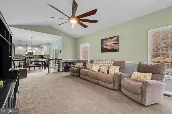 a living room with furniture and kitchen view
