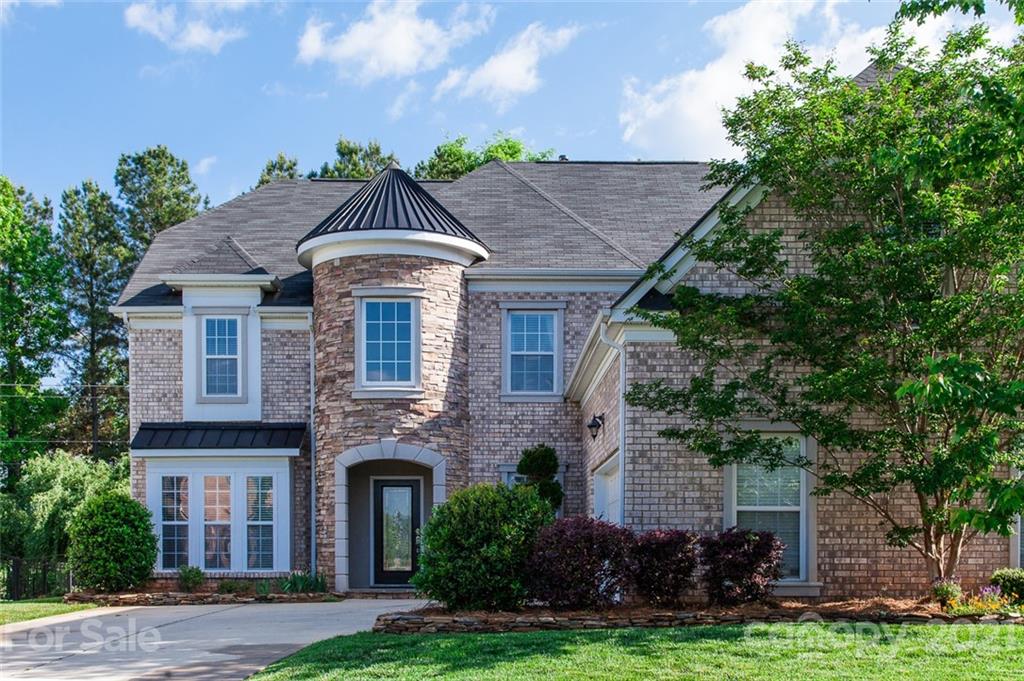 1032 Spanish Moss Road Indian Trail, NC 28079 - Photo 1 of 37 a front view of a house with a yard and trees
