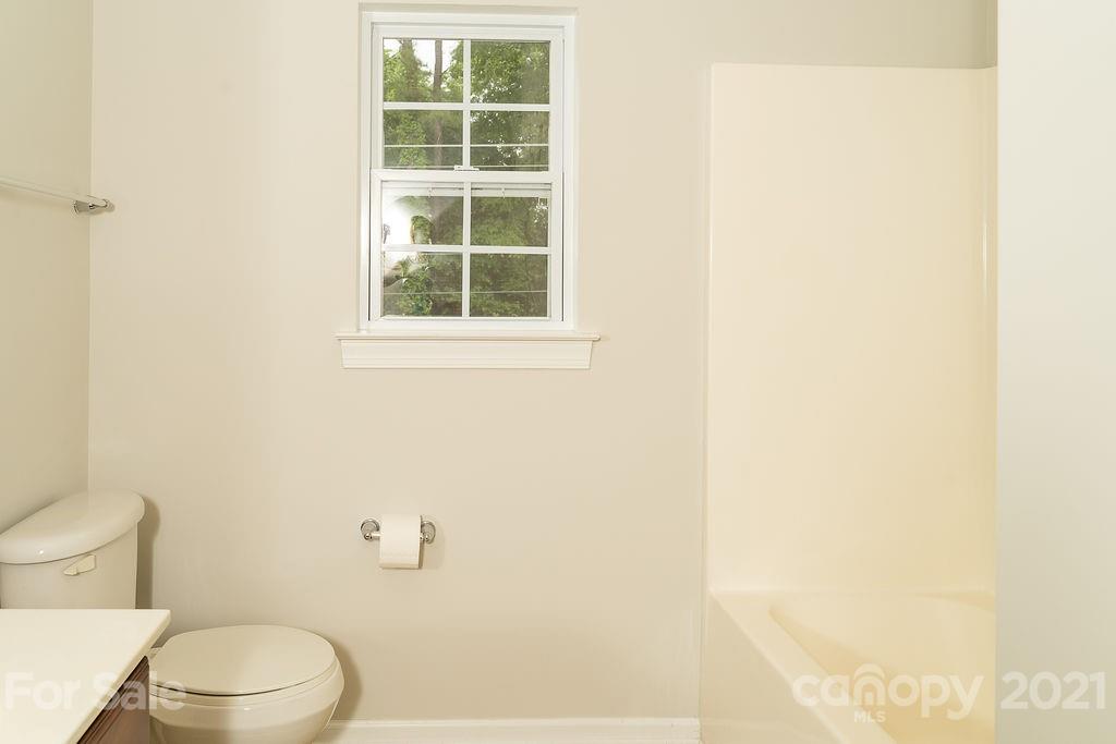1032 Spanish Moss Road Indian Trail, NC 28079 - Photo 32 of 37 a white toilet sitting next to a bathroom sink