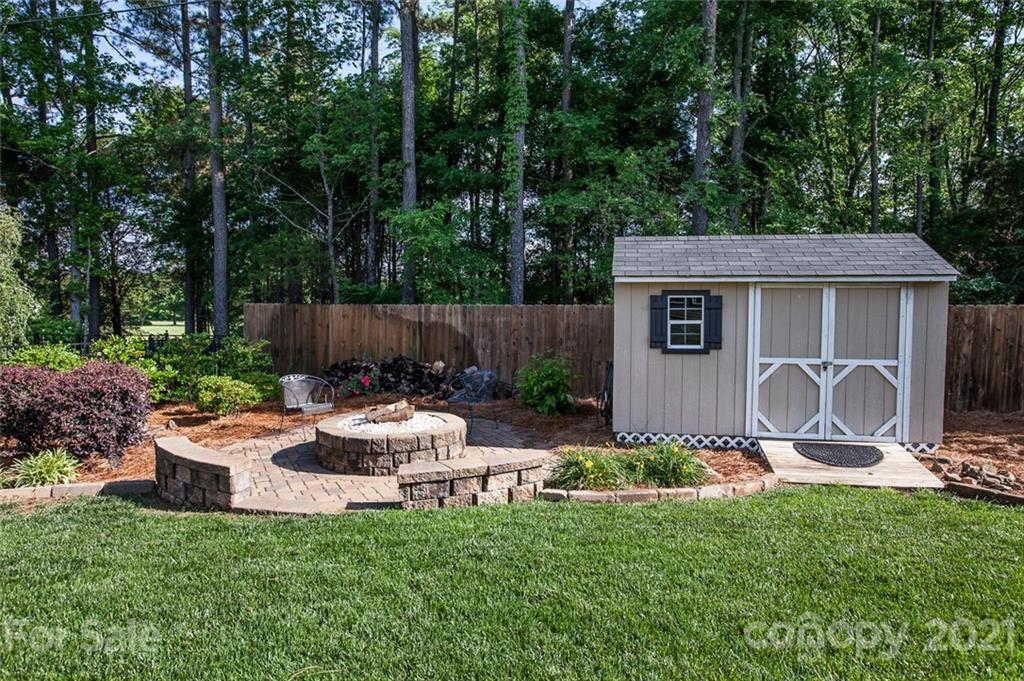 1032 Spanish Moss Road Indian Trail, NC 28079 - Photo 37 of 37 a view of a backyard with table and chairs potted plants and large tree