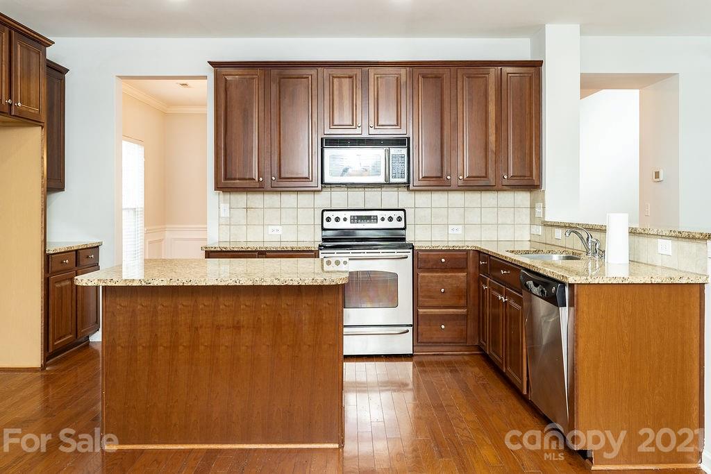 1032 Spanish Moss Road Indian Trail, NC 28079 - Photo 5 of 37 a kitchen with stainless steel appliances granite countertop a stove a sink and a refrigerator