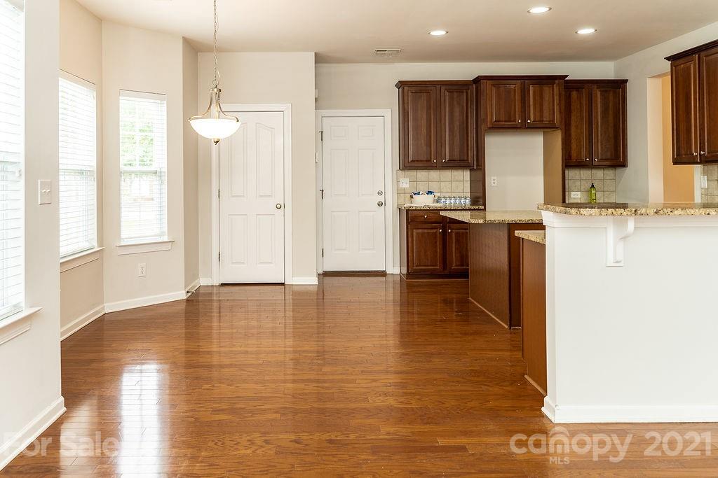 1032 Spanish Moss Road Indian Trail, NC 28079 - Photo 7 of 37 a kitchen with stainless steel appliances granite countertop a refrigerator a stove top oven a sink and dishwasher with wooden floor