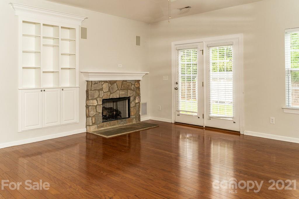 1032 Spanish Moss Road Indian Trail, NC 28079 - Photo 10 of 37 an empty room with wooden floor fireplace and windows