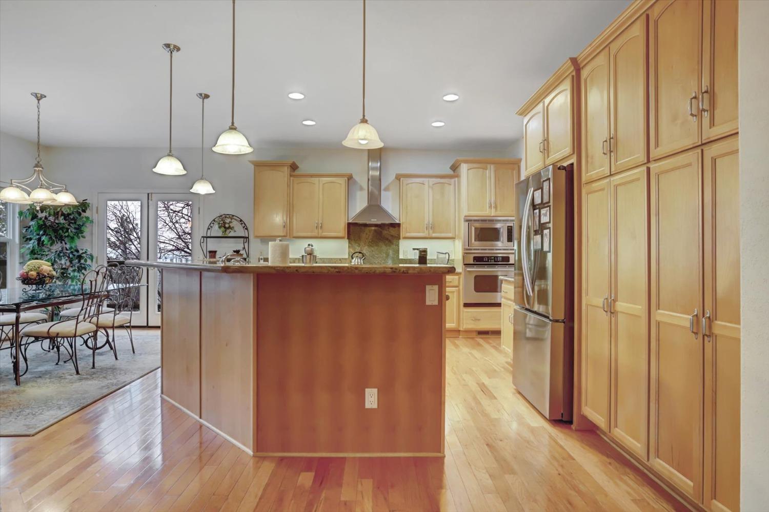 17036 Alice Way Grass Valley, CA 95949 - Photo 14 of 58 a kitchen with stainless steel appliances granite countertop a refrigerator a oven a stove and a dining table with wooden floor