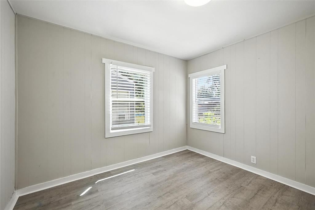 204 Graham Avenue Bonham, TX 75418 - Photo 7 of 21 Unfurnished room with wood finished floors and wooden walls
