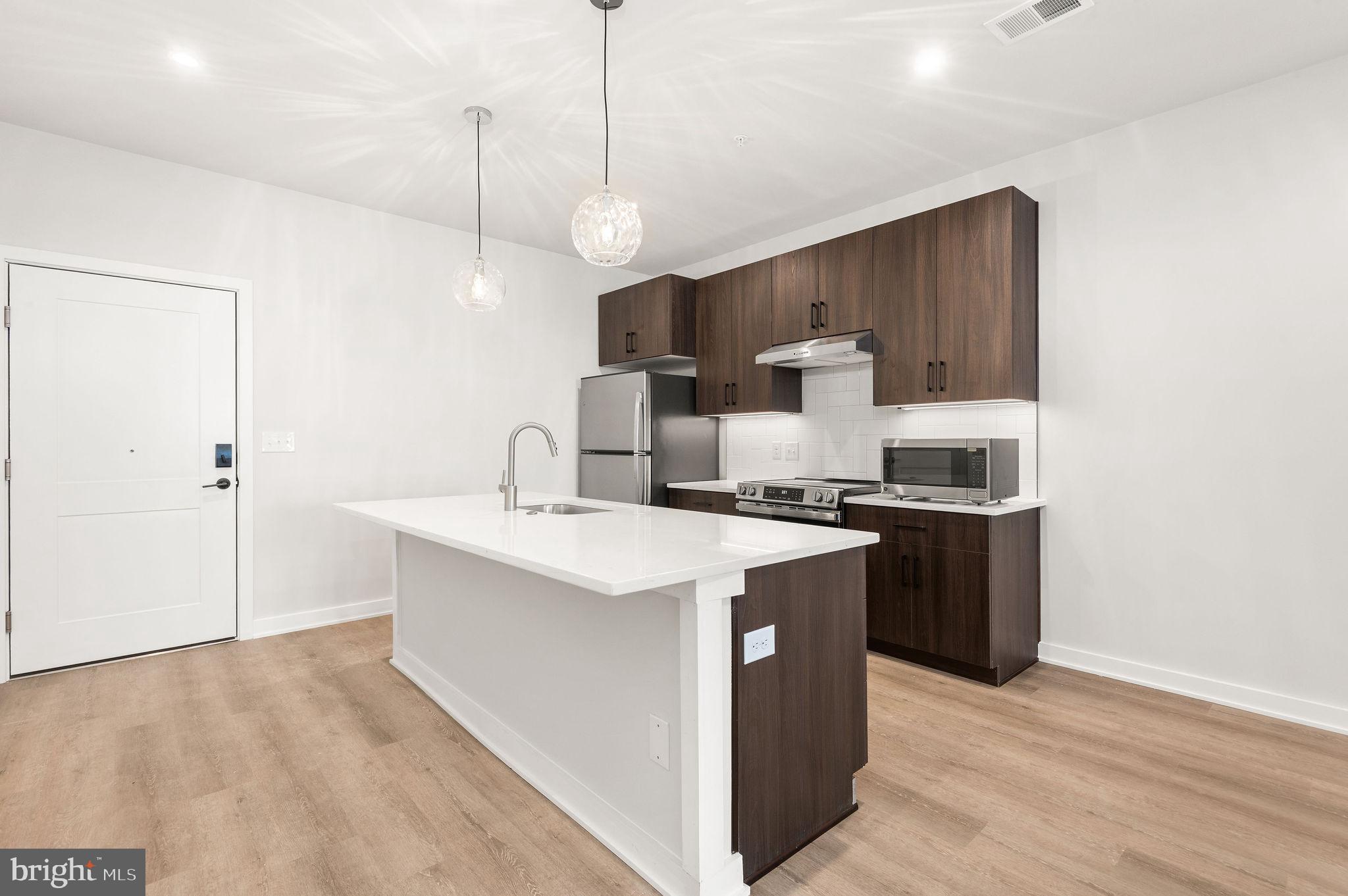 a kitchen with kitchen island a sink stainless steel appliances and cabinets