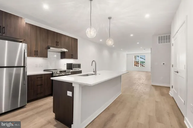a kitchen with stainless steel appliances granite countertop a sink a stove and a refrigerator