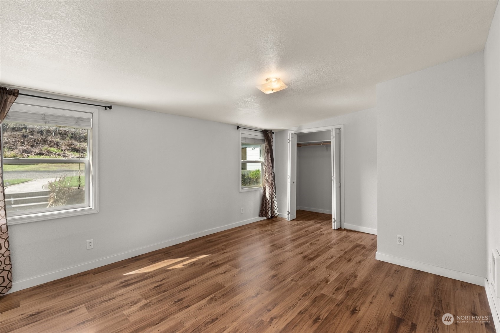 370 Manners Road Rochester, WA 98579 - Photo 21 of 34 a view of an empty room with wooden floor and a window