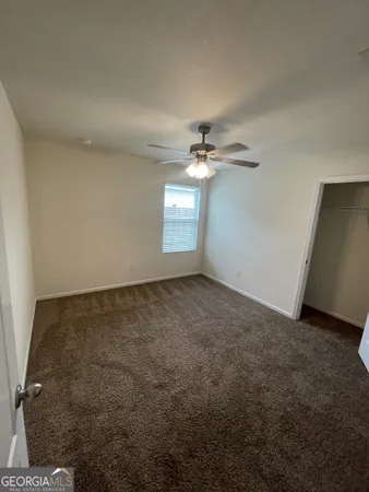 a view of an empty room with a chandelier fan