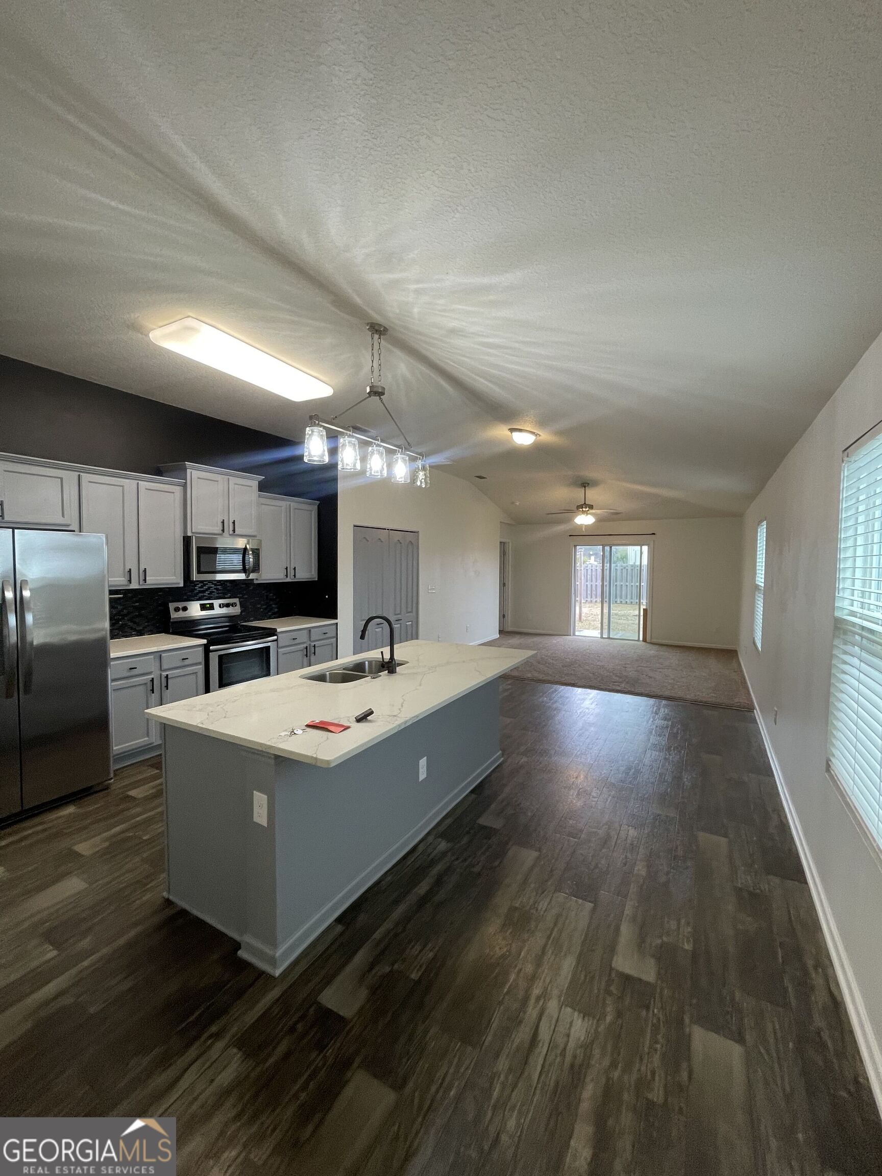 25 Fox Path St. Marys, GA 31558 - Photo 4 of 22 a large white kitchen with kitchen island a stove a refrigerator a sink dishwasher with a dining table and chairs
