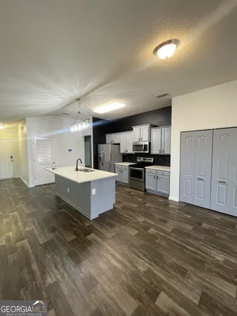 a large living room with stainless steel appliances kitchen view and living room view