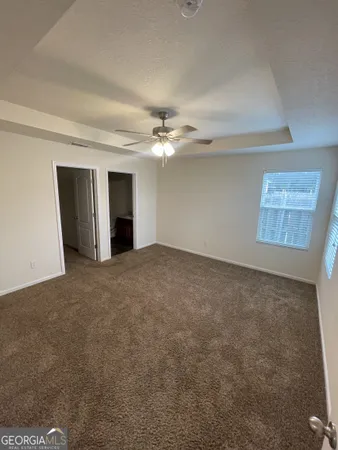 a view of a livingroom with a ceiling fan and window