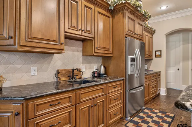 a kitchen with stainless steel appliances granite countertop a refrigerator and cabinets