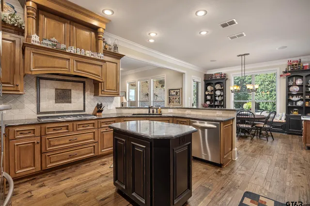 a kitchen with kitchen island a sink and a stove top oven