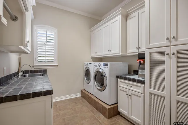 a utility room with sink dryer and washer