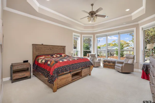 a bed sitting in a spacious bedroom next to a window