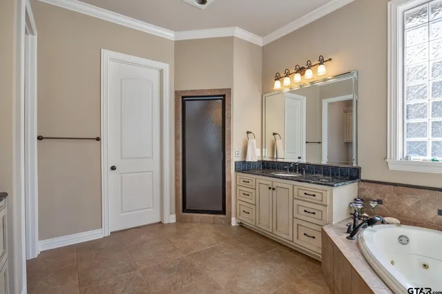 a bathroom with a granite countertop sink tub and a mirror