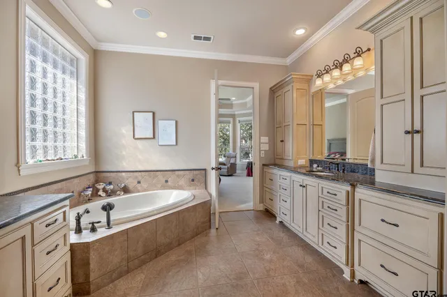 a spacious bathroom with a double vanity sink a mirror and a bathtub