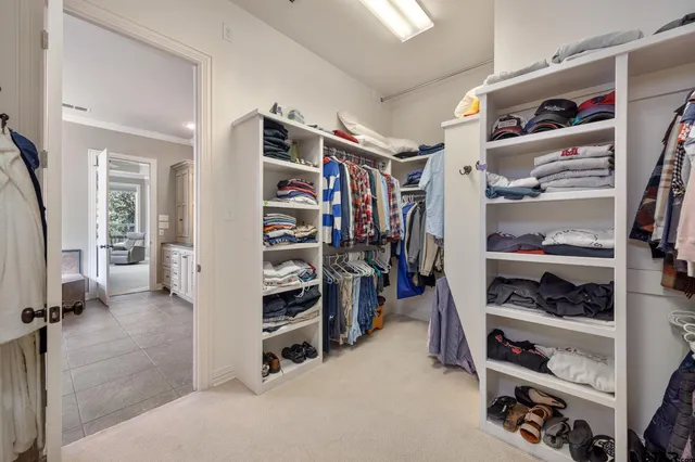 a view of walk in closet with clothes and shoes
