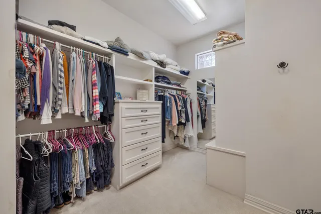 a view of walk in closet with clothes
