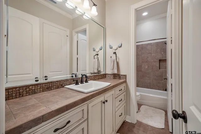 a bathroom with a granite countertop sink a mirror and a bathtub