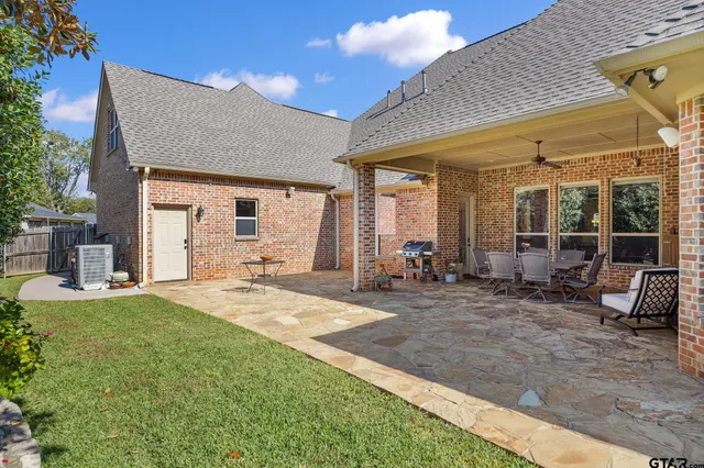 a view of a house with backyard and sitting area