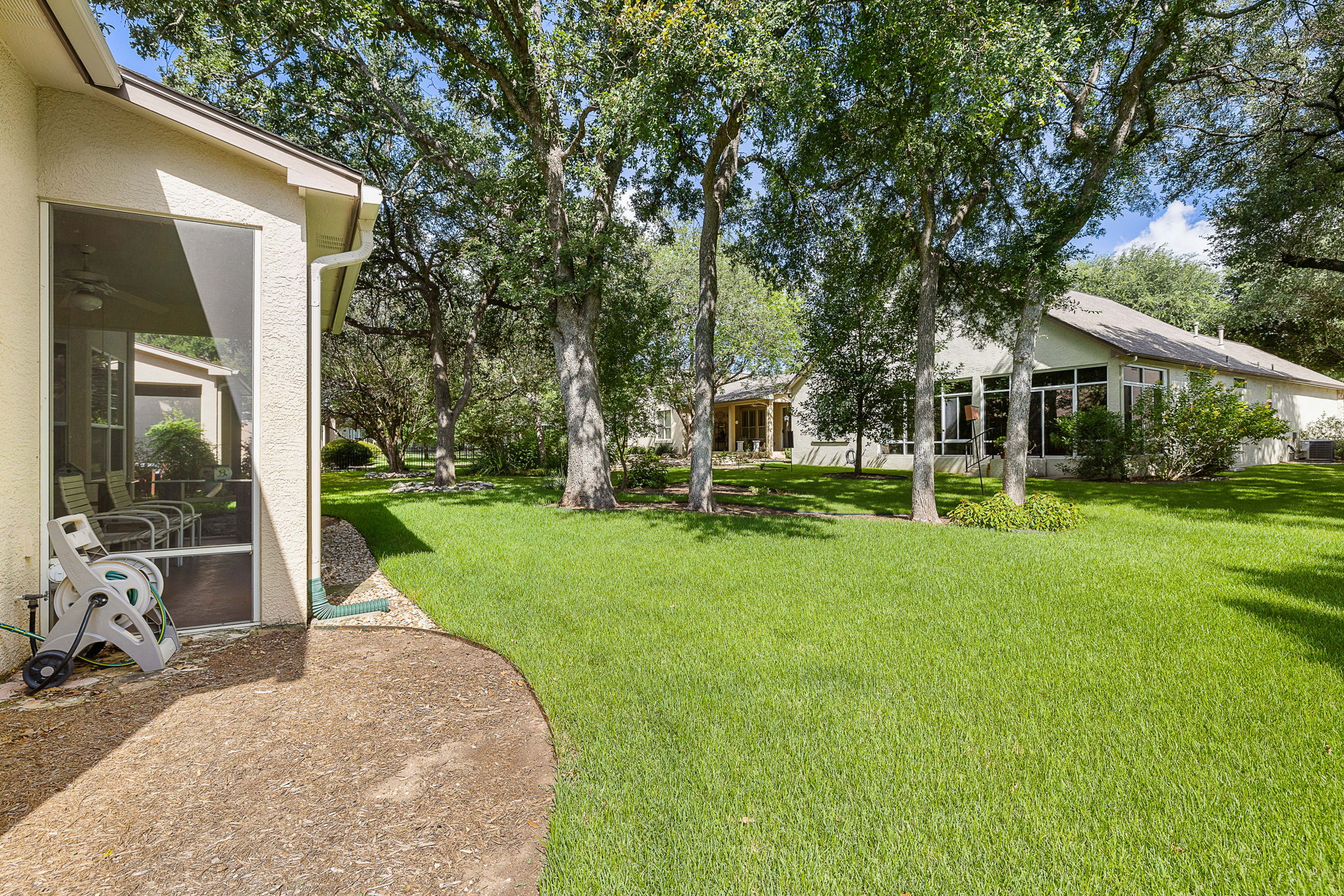191 Trail Rider Way Georgetown, TX 78633 - Photo 20 of 25 A spacious yard with mature trees provides ample shade for this stucco home with a screened porch.
