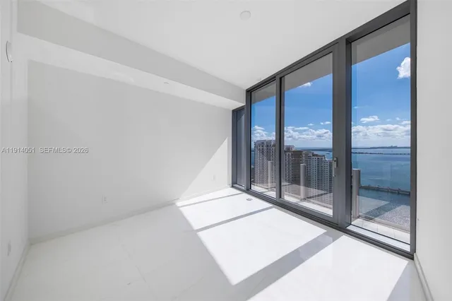 a view of a kitchen with a sink and an empty room