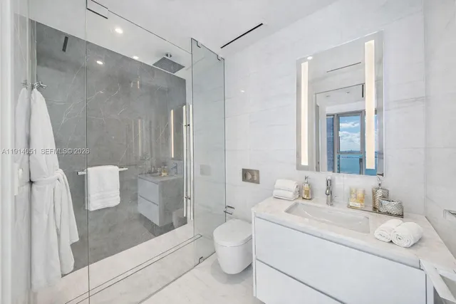 a hotel room with two couches and a flat screen tv