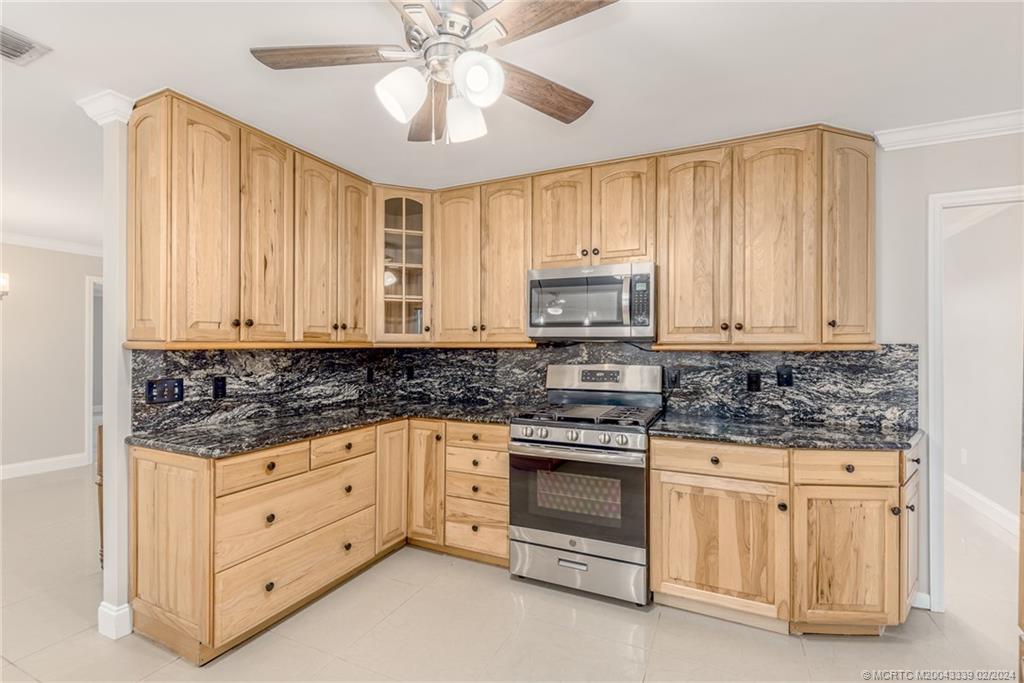 1469 Northwest Fork Road Stuart, FL 34994 - Photo 20 of 39 a kitchen with stainless steel appliances granite countertop a stove a sink and a microwave