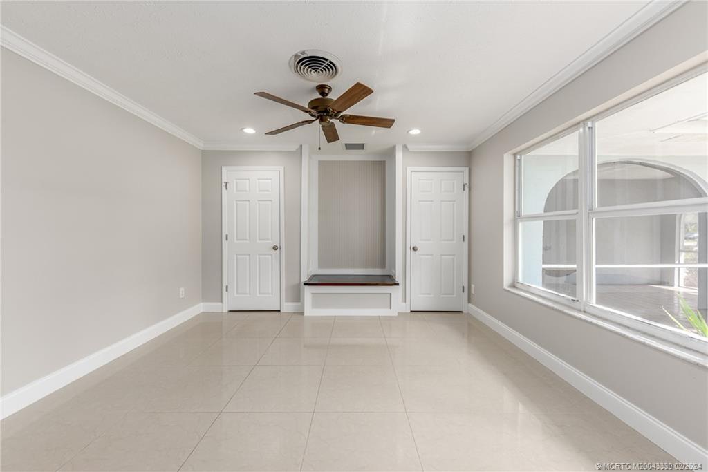 1469 Northwest Fork Road Stuart, FL 34994 - Photo 22 of 39 an empty room with windows and fan