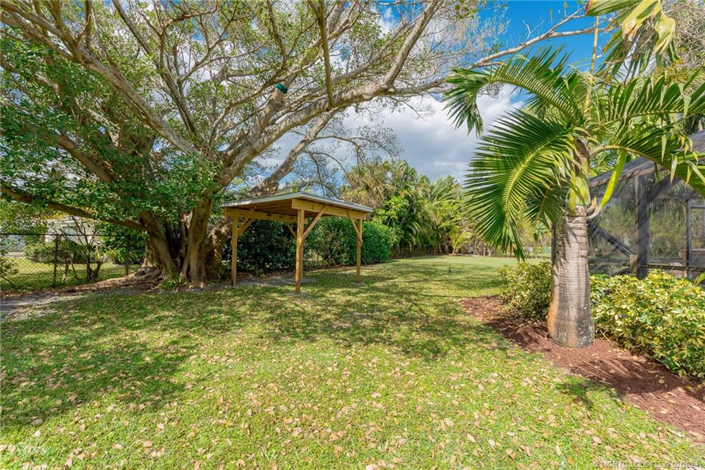 1469 Northwest Fork Road Stuart, FL 34994 - Photo 31 of 39 a backyard of a house with table and chairs