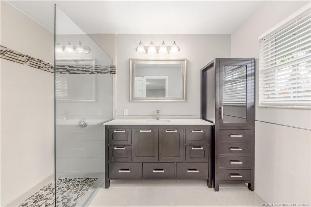 1469 Northwest Fork Road Stuart, FL 34994 - Photo 6 of 39 a bathroom with a sink vanity and mirror