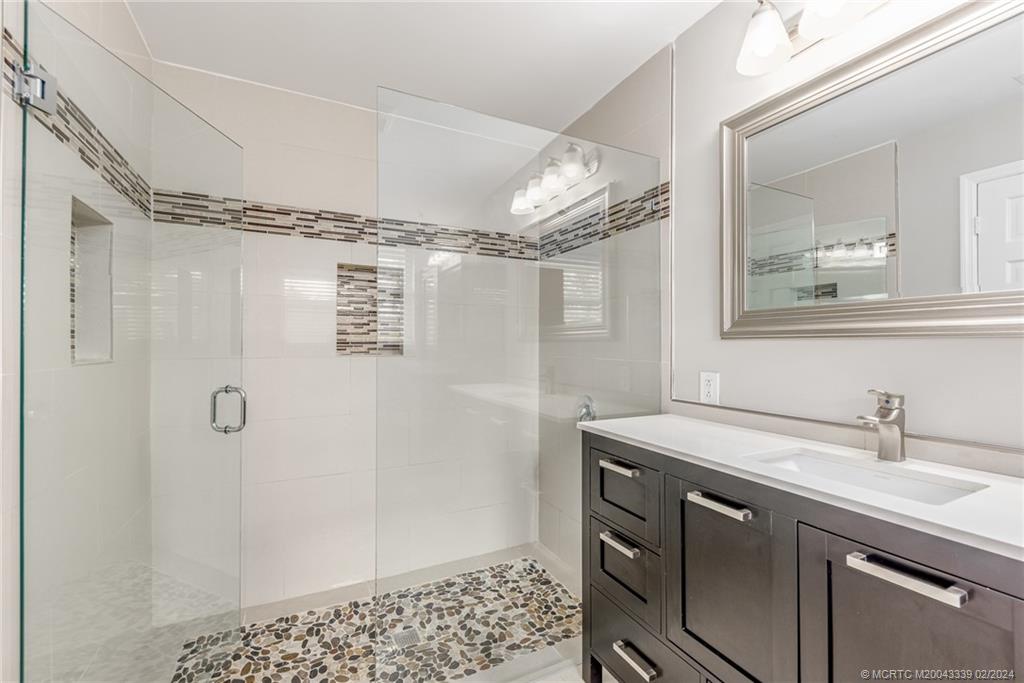 1469 Northwest Fork Road Stuart, FL 34994 - Photo 7 of 39 a bathroom with a sink and a mirror